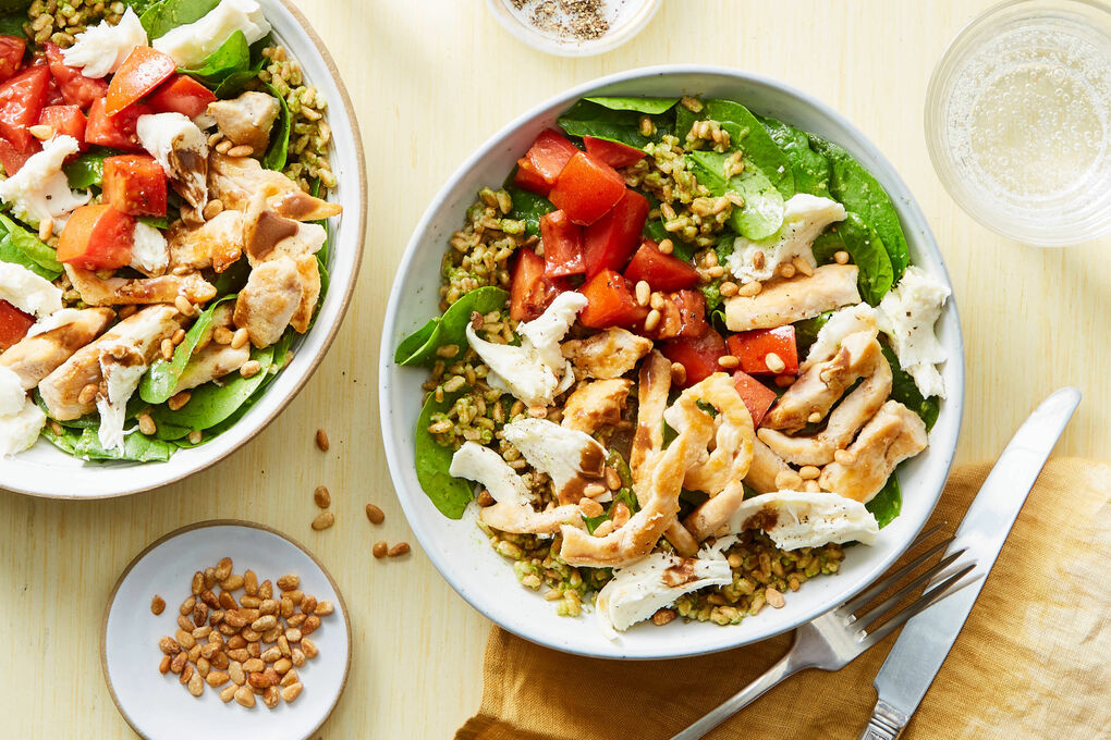 Pesto chicken farro meal prep bowl with grilled chicken sun-dried tomatoes farro arugula and basil pesto drizzle