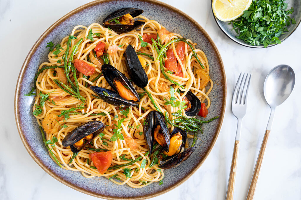 Spaghetti med musslor och glasört i en lätt tomatsås | Marley Spoon