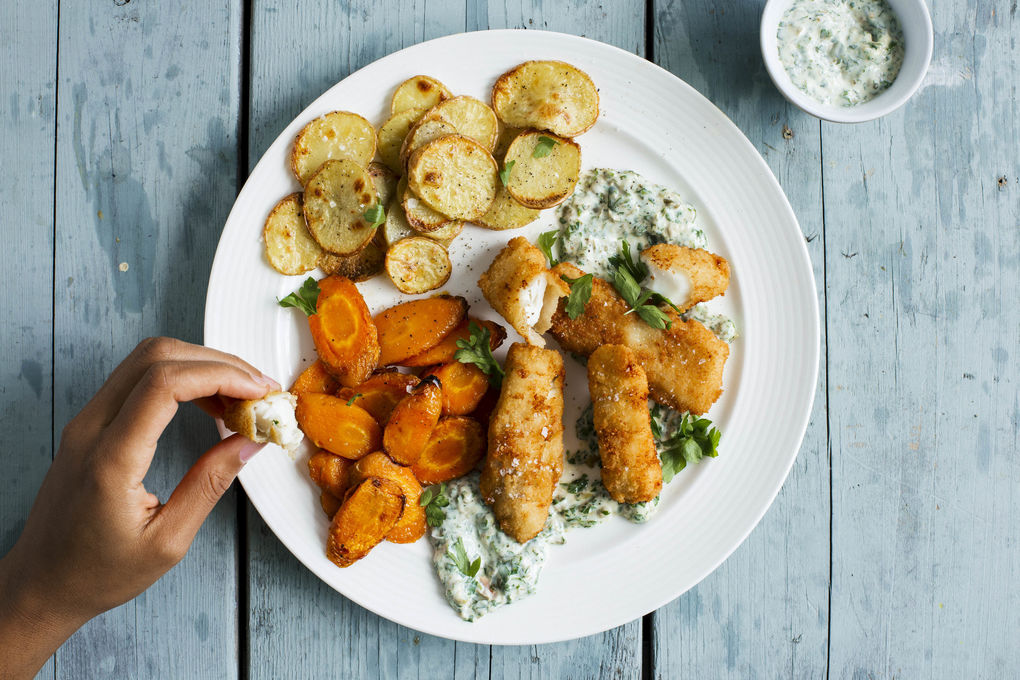 Homemade fish sticks of hake fillet with oven vegetables and a creamy caper dip