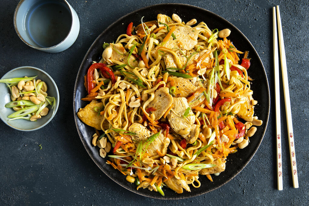 Vegetable stir fry with chicken and noodles and roasted peanuts