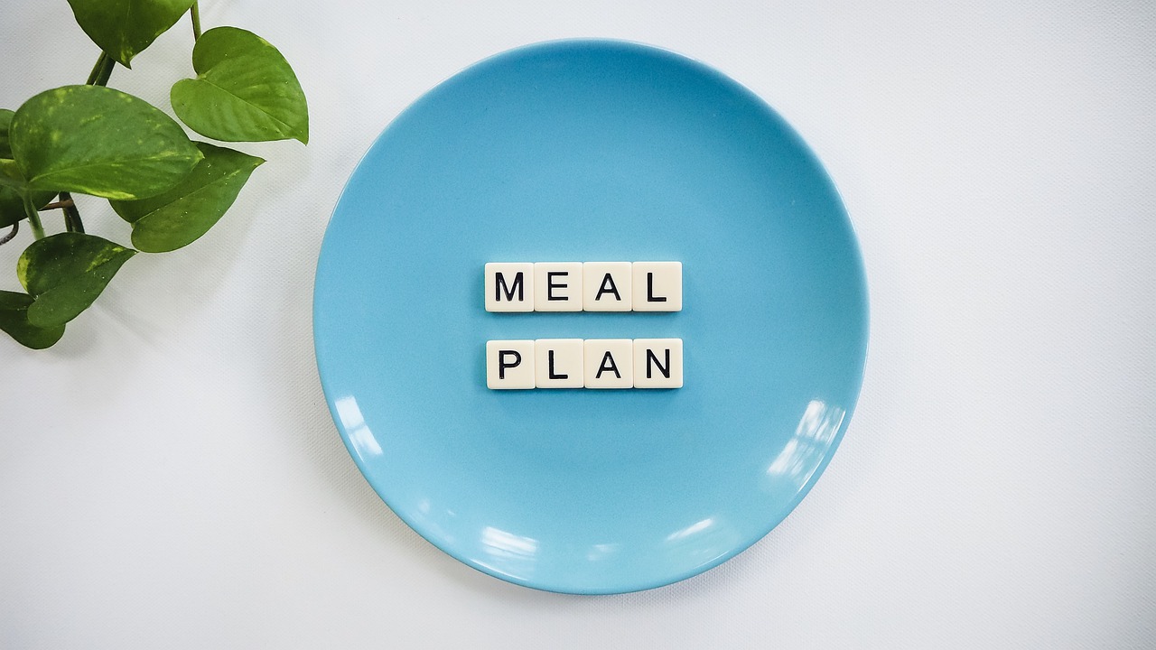 Meal Plan written in Scrabble letters in the middle of bright blue plate
